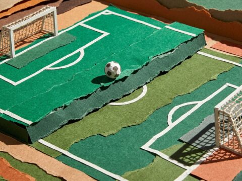 Tampilan data pasaran pertandingan sepak bola pada layar ponsel di atas meja